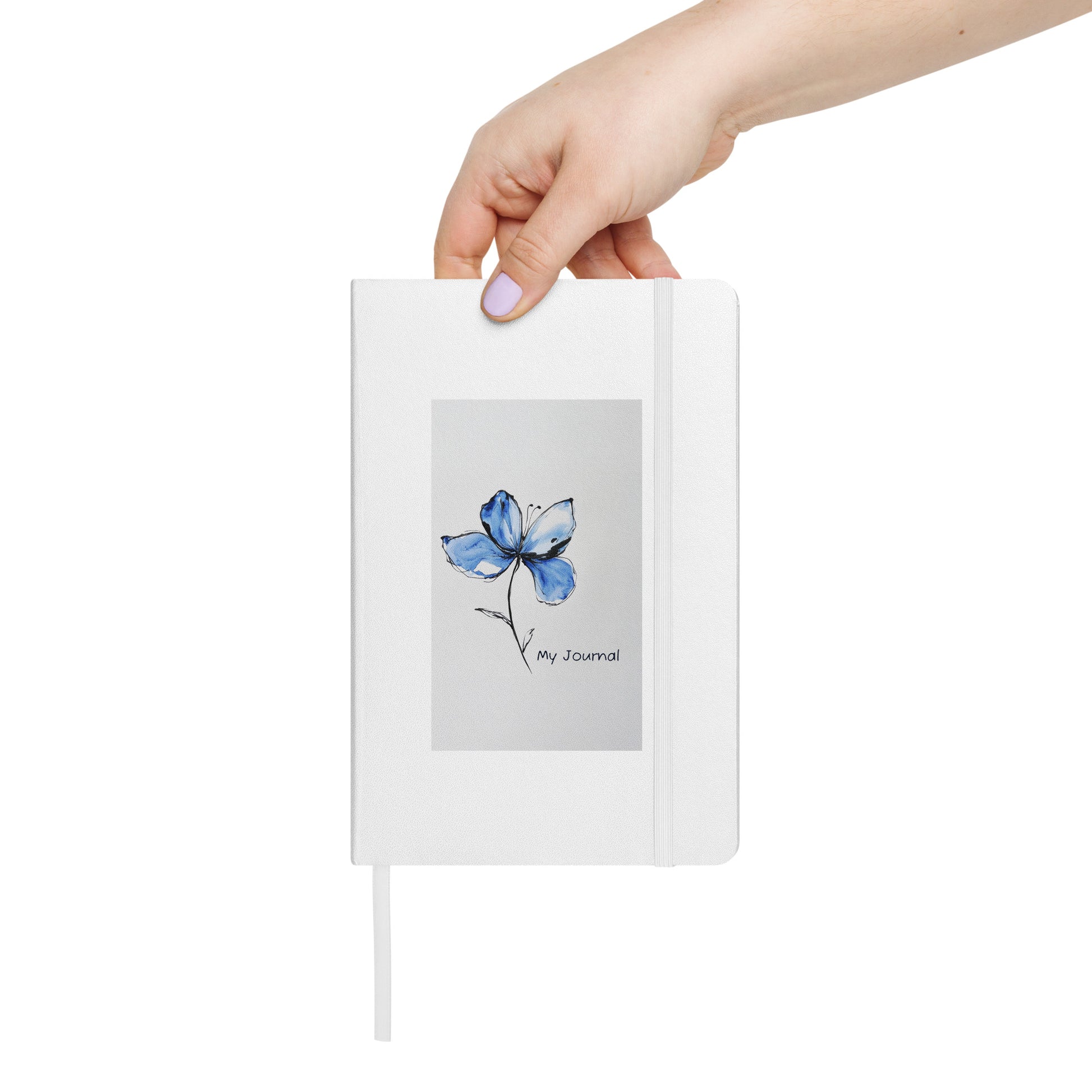 A hand holding a Product mockup of a white journal with a Blue Butterfly Bean flower on it and the words My Journal